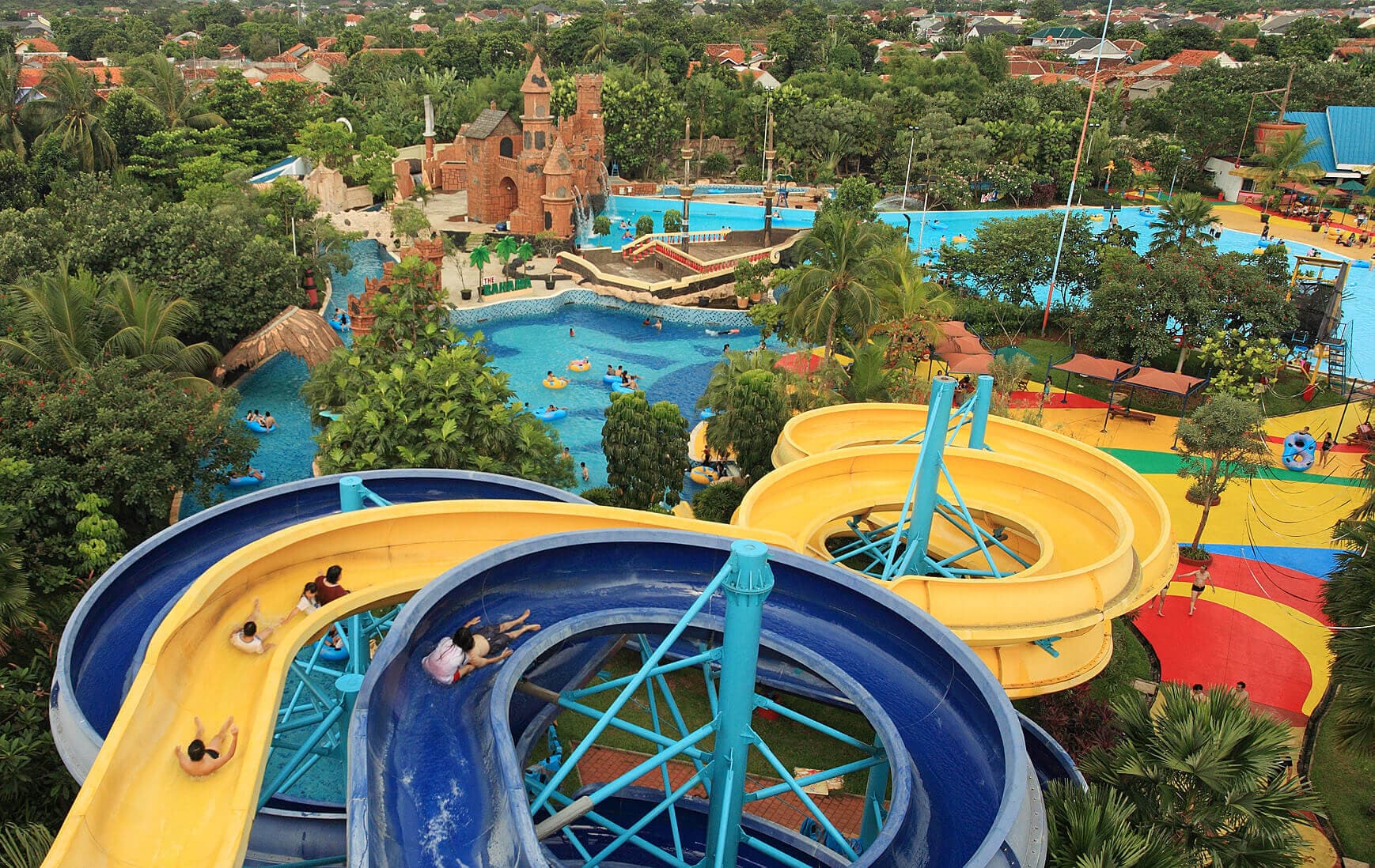 Siap-siap meluncur kencang! 🚀💨 Perosotan spiral kuning dan biru ini not for the faint-hearted. Siapa yang berani coba paling tinggi? 😎🔥 